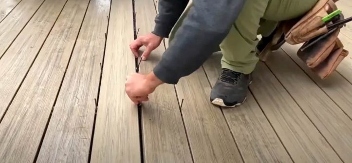 Worker repairing spongy deck with epoxy wood filler