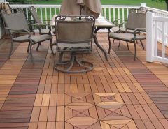 Workers snapping interlocking deck tiles on a sunny rooftop deck for easy installation