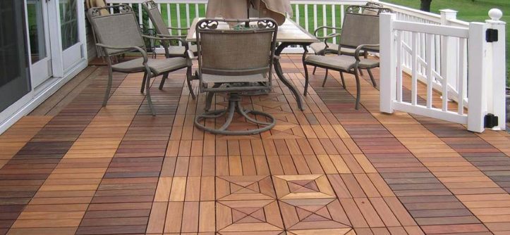 Workers snapping interlocking deck tiles on a sunny rooftop deck for easy installation