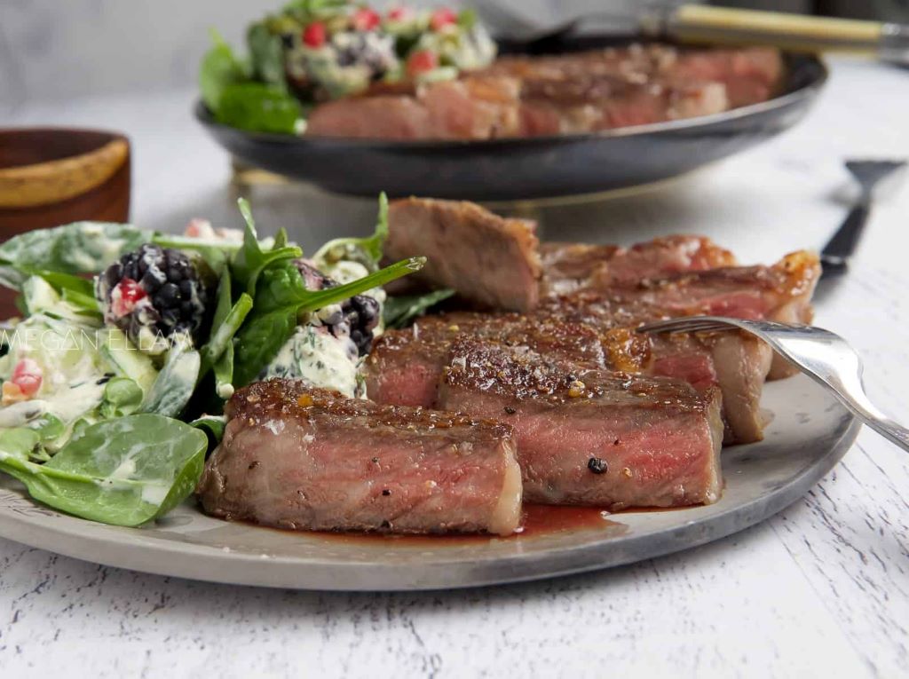 A vacuum-sealed A5 Wagyu steak submerged in a clear sous vide water bath with an immersion circulator maintaining the temperature
