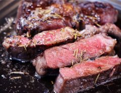 A perfectly cooked A5 Wagyu steak, sliced thin to reveal a consistent medium-rare pink interior and a dark, seared crust