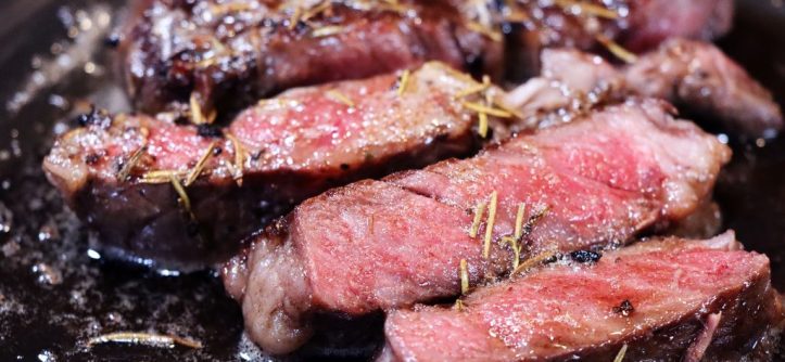 A perfectly cooked A5 Wagyu steak, sliced thin to reveal a consistent medium-rare pink interior and a dark, seared crust