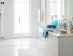 Clean white bathroom with sparkling fixtures and organized cleaning supplies on counter