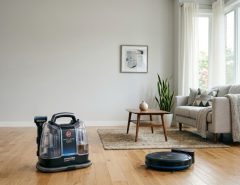 Modern Hoover upright and cordless stick vacuum cleaners in a bright living room.