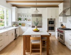 A sunlit, clean quartz kitchen island with small vase and white towels.